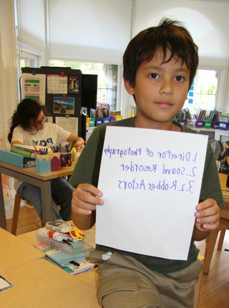 Lower School After School student with sign for filmmaking